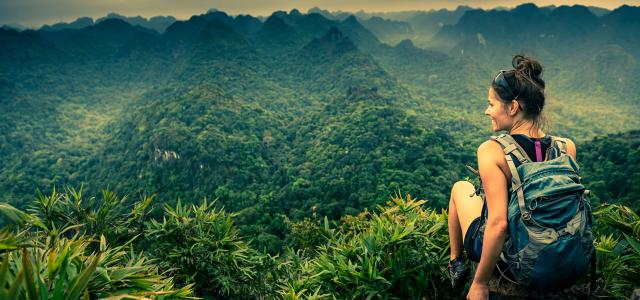 Girl sitting on top of mountain